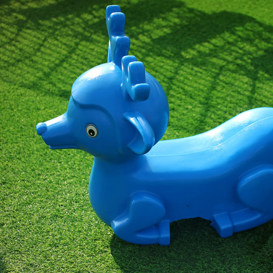 a plastic reindeer on artificial turf