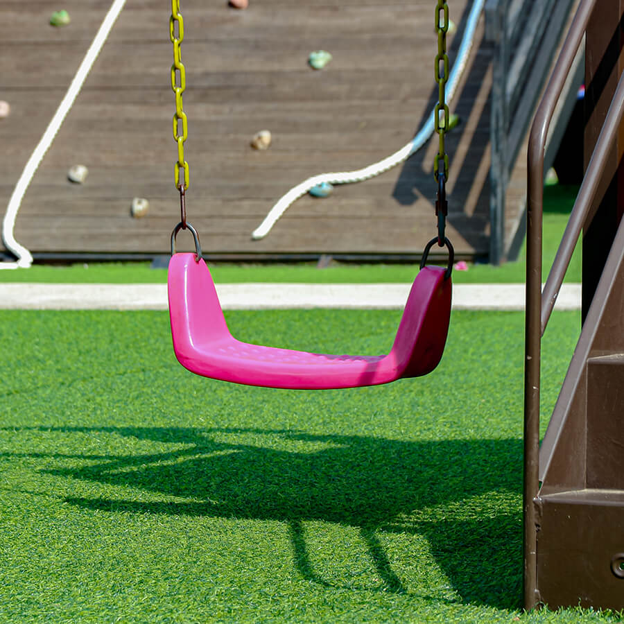 a swing set on artificial turf at a school